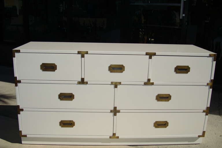 Newly lacquered white gloss seven drawer campaign dresser with burnished brass hardware.