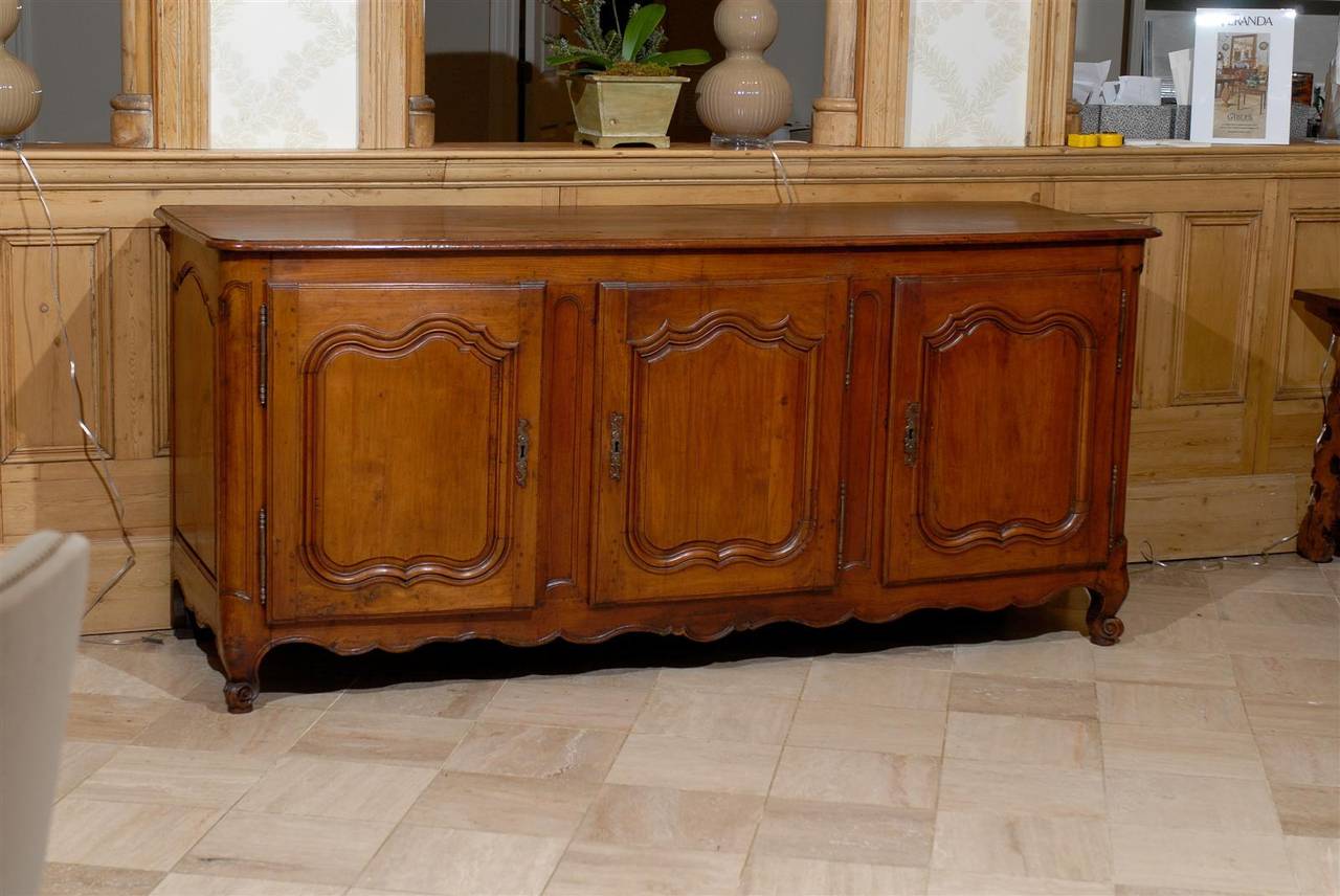This elegant enfilade has the kind of patina which makes you just want to rub your hands over  it's  warm wood.   It has simple lines with movement on the doors and the apron.  Enfilades offer you lots of storage and can be used in dining rooms,