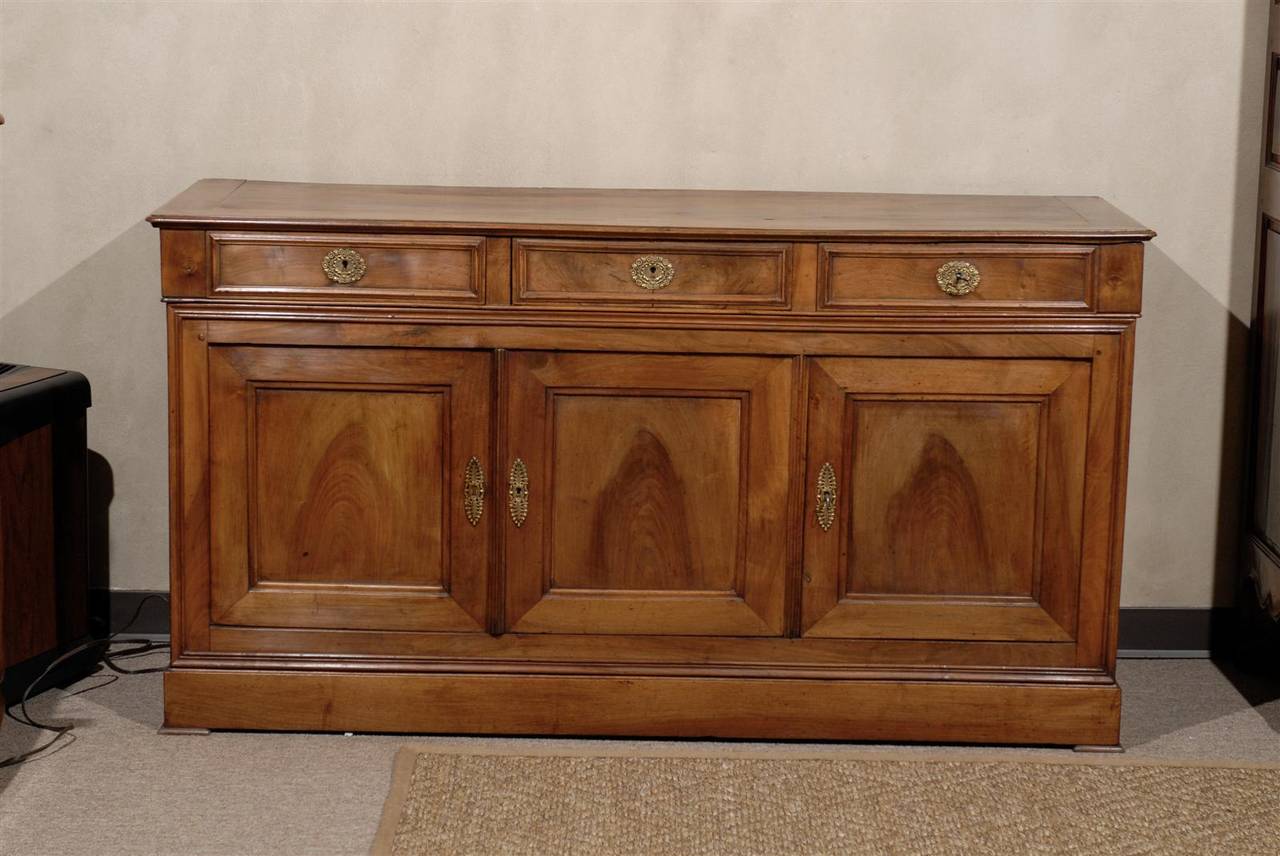 The beautiful, natural patterns of the French walnut are what make this enfilade very special.  The variety of tones and shades would make it easy to pair it  with woods of any color. Very attractive bronze escutcheons on all three drawers and doors