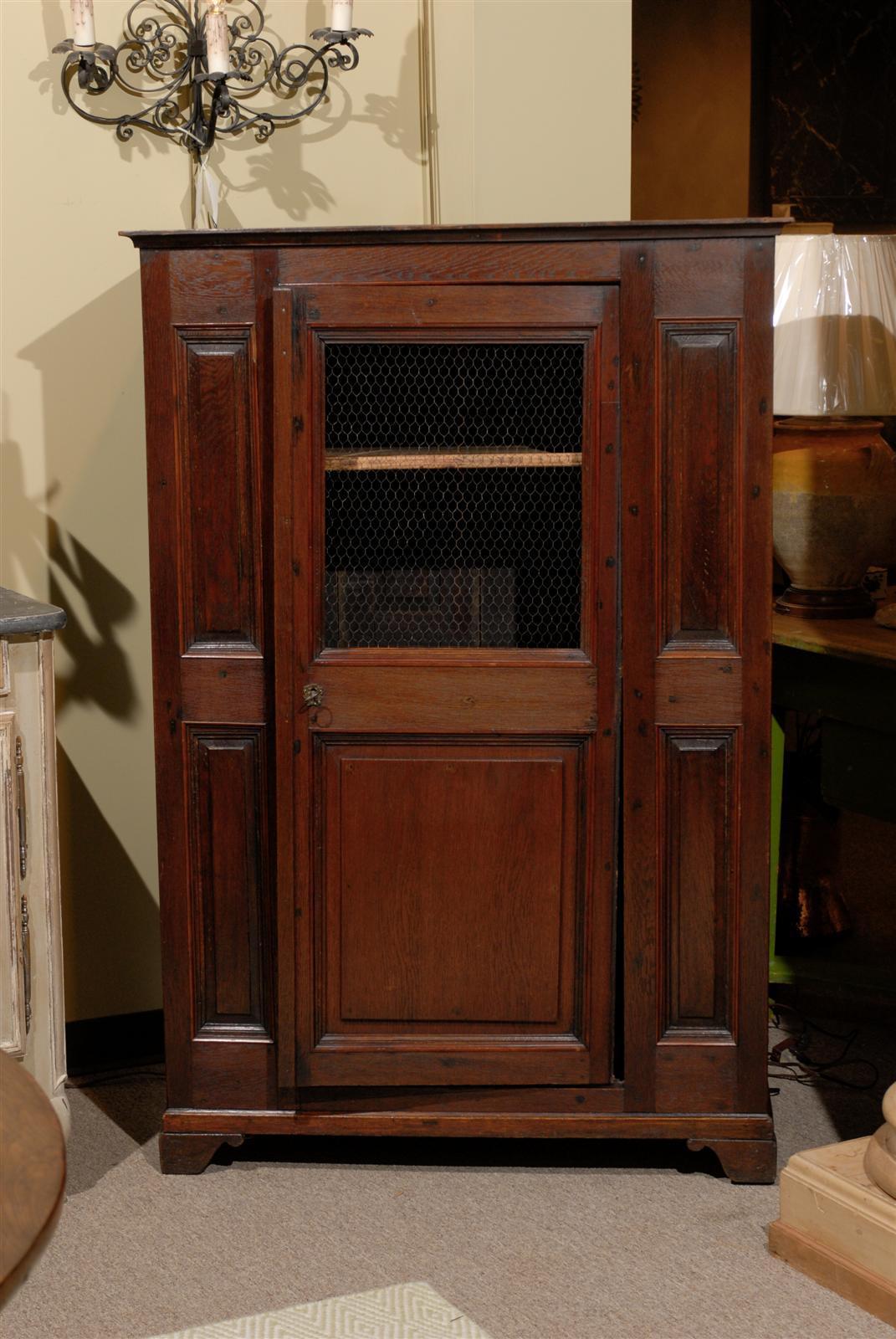 This charming cabinet with the chicken wire door was probably used in a country kitchen somewhere in Brittany. It is narrow in depth but affords great storage. This cute little piece has been made with pine and oak.