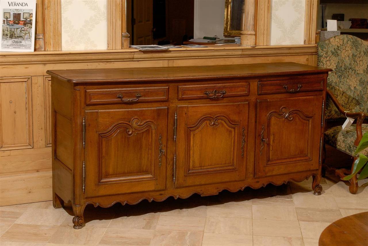 This 19th century enfilade is made of beautiful Brittany oak.  It has a gorgeous patina and is made in the style of Louis XV with curved lines on the doors and snail feet. The enfilade has good proportions and great lines!