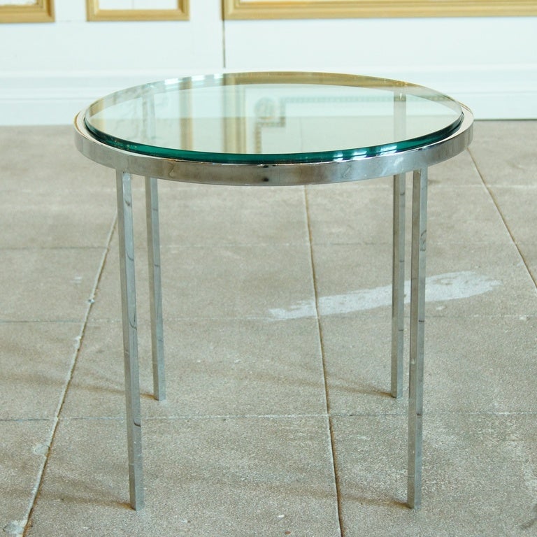 Round polished stainless steel and glass side table in the style of Nicos Zographos, USA, 1980's.
