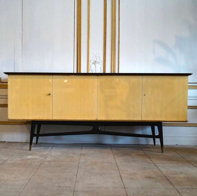 This is a beautiful buffet and bar made of sycamore, ebonized wood and the legs end with brass sabots. It bears a tag Ameublement NF which is a private quality control company.
This piece looks amazing in person but has definite signs of age and