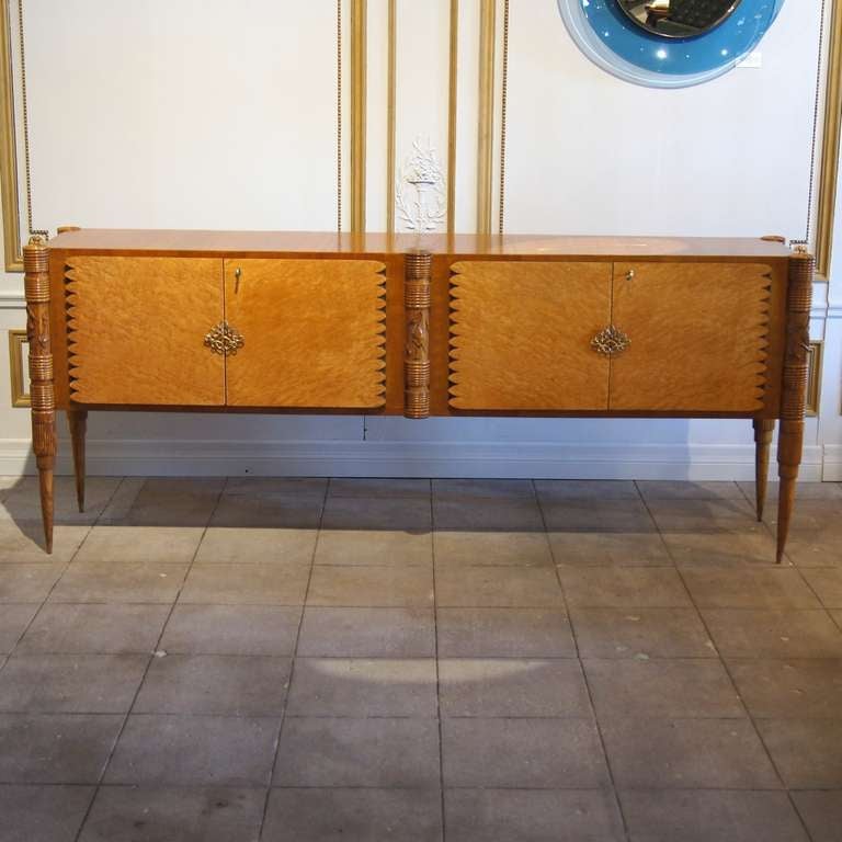 Beautiful 4 door buffet by Pier Luigi Colli. The doors are made of birds eye maple. The structure is made of a oak with carved legs depicting birds, foliage, vertical and horizontal reeding. There is one shelf per side (not shown - newly made). Top