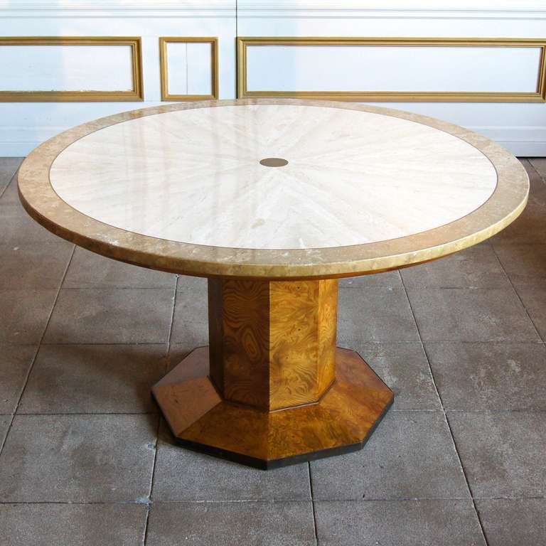 Burlwood center table by John Widdicomb with a sunburst, two toned travertine top. The top also has and inlayed brass center point and outer band. The bottom of the pedestal is also banded in brass. The brass shows a great patina, but could be