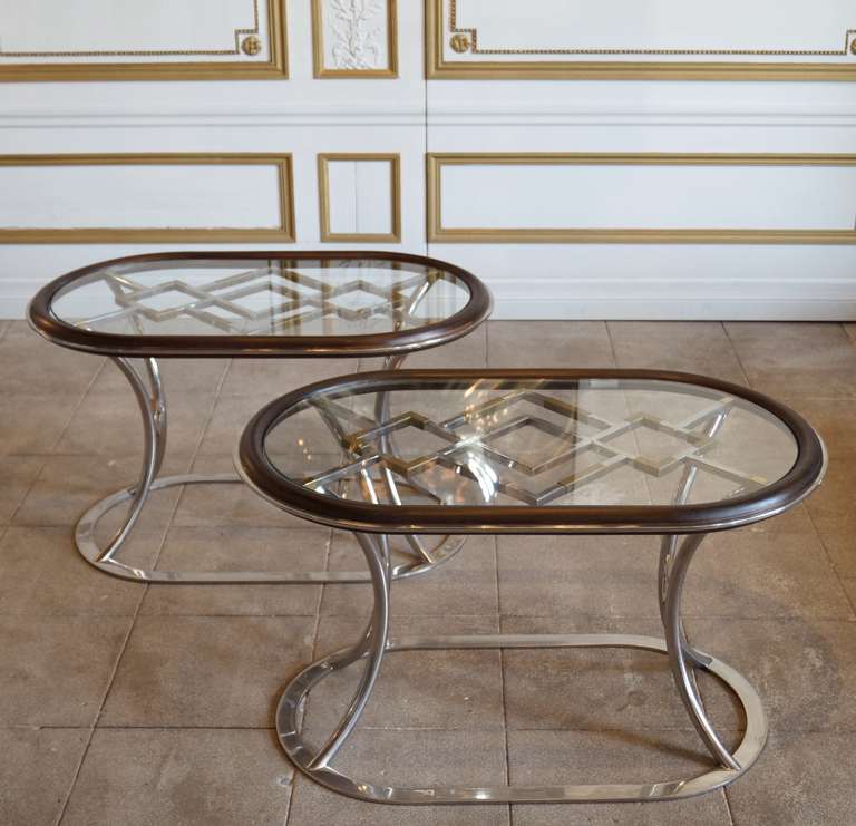 This elegant pair of side tables were part of the Alain Delon line for Maison Jansen collections circa 1972. The mahogany has a great patina. The polished steel is in very good condition and the brass shows some patina. It could be polished.