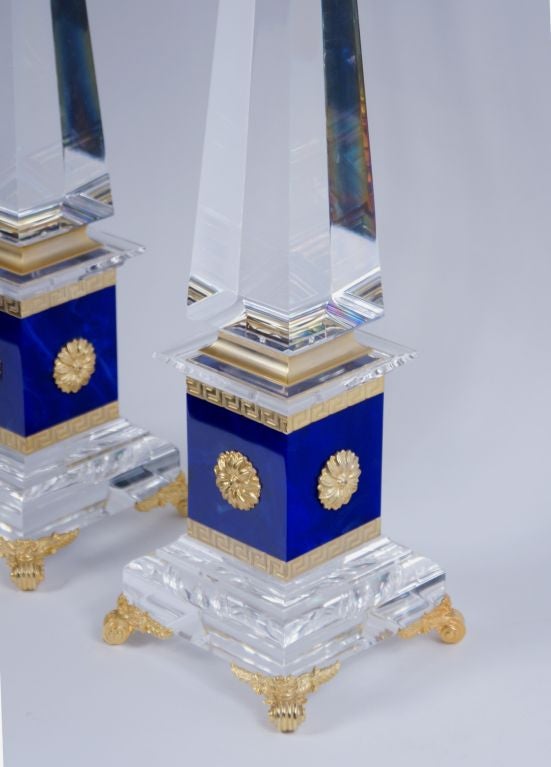 Large pair of Obelisks in the style of Versace. Clear lucite, blue faux malachite lucite and brass with greek key design.