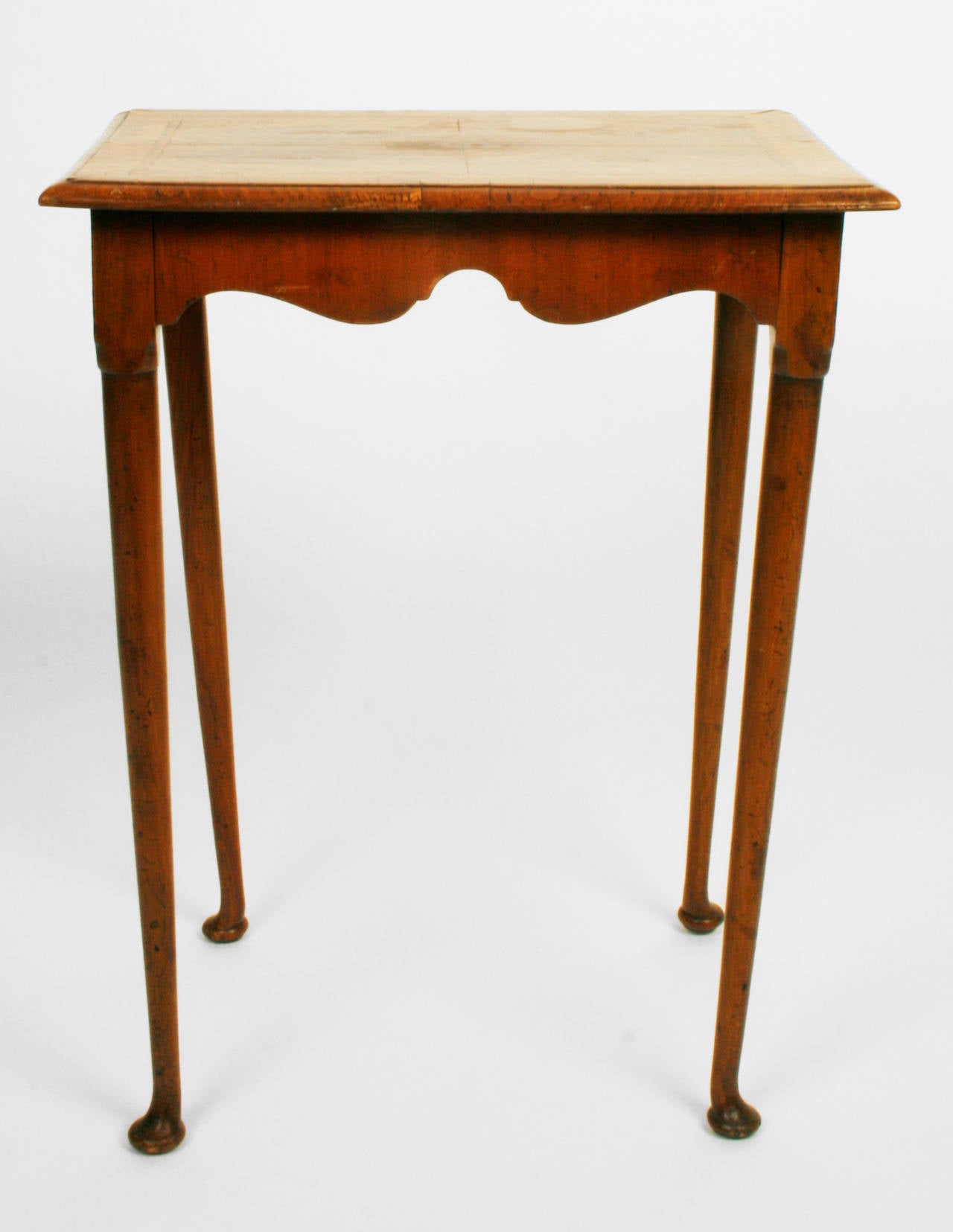 This graceful side table is in the Queen Anne style. It is made of burled walnut with a bookmatch veneered top, scalloped apron and cabriole legs. The perfect side table for a room needing a light touch.