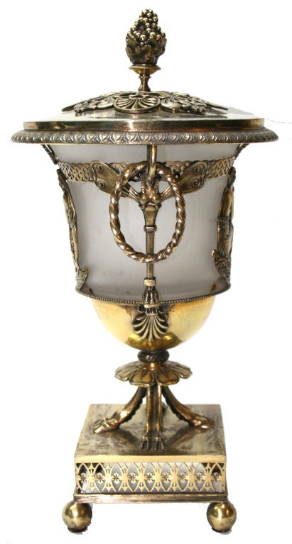 Cette belle épergne française du début du XIXe siècle en argent sterling doré est décorée de figures féminines classiques, d'angelots, de libellules et de têtes égyptiennes, elle repose sur des pieds à sabots. Le couvercle est orné d'une poignée de