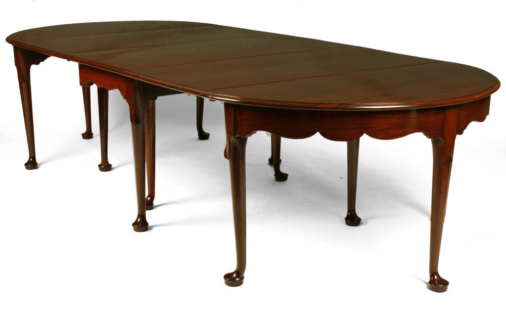 This beautiful English table has many configurations. The two “D” ends with scalloped apron can be used together as a round table or with the drop-leaf center table. The ends also can be placed on the wall as two consoles. The center section with