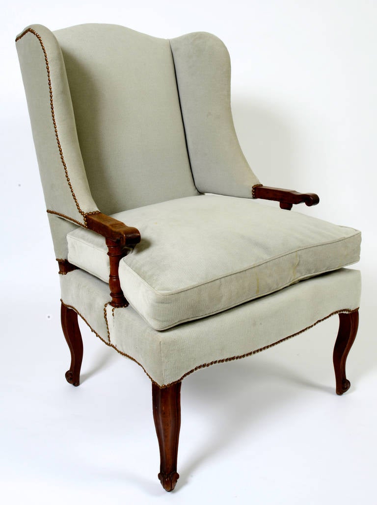 This large scaled bergère is made of a rich walnut, with exposed turned arm supports, cabriole legs and scrolled feet. It has a handsome size making it the perfect comfortable chair for the man in the family. 
