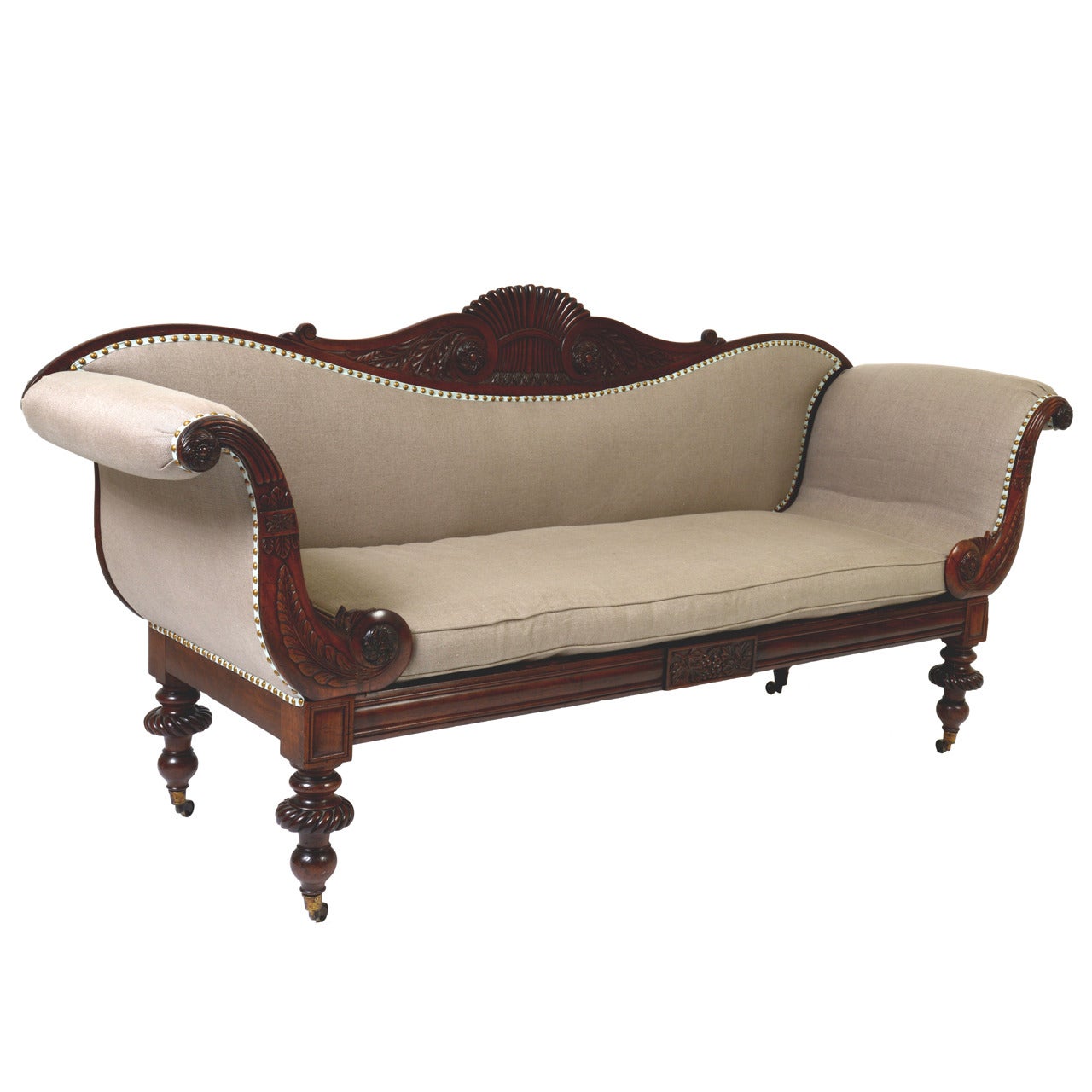 This beautiful mahogany sofa is carved with a typical center back “Jamaican finial” of a sheath of wheat. The arms are carved with curving tropical leaves and rosettes. The graceful sofa seems to float on its bulbous turned feet and original brass