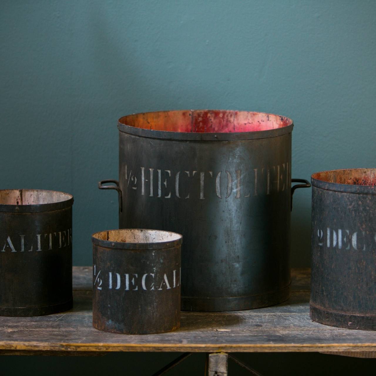 Set of for iron measures. Hand-painted with hand-stenciled lettering. Likely use in a Belgian factory. The largest measure of the set has handles. Measures measure 16, 12, 9 and 7.5 inches in diameter.