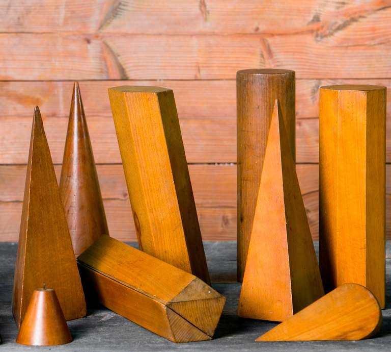 Set of nine vintage wooden geometric shapes from a Belgian school house. Likely date from the 1950s. The shapes range in height from 3 to 13 inches and range in width from 2 to 4 inches.