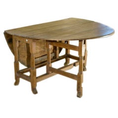 Antique oak drop-leaf table with animal paw foot