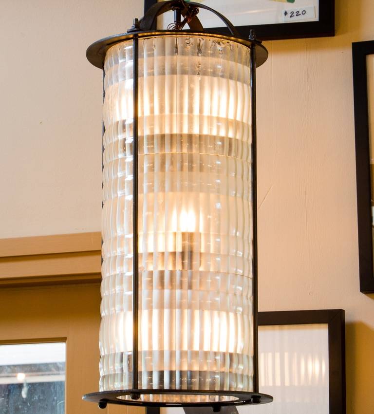 Single unusual and rare light. Black iron frame with heavy molded frosted glass. Originally hung in the lobby of a French banque. The lantern has three tiers with three lights on each tier. There are a total of nine candelabra sockets. The light has