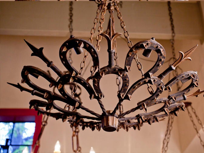 Hand-made chandelier with horseshoe and fleur de lys motif.