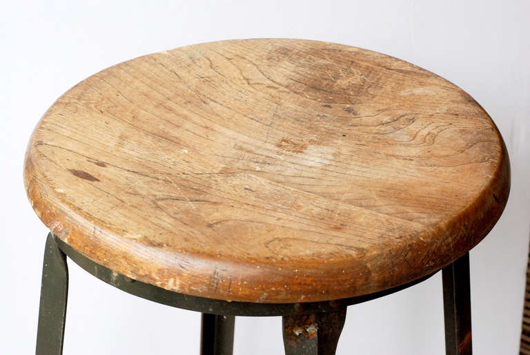 Vintage American work stool. Steel base with natural patina and wooden seat. Base measures 21
