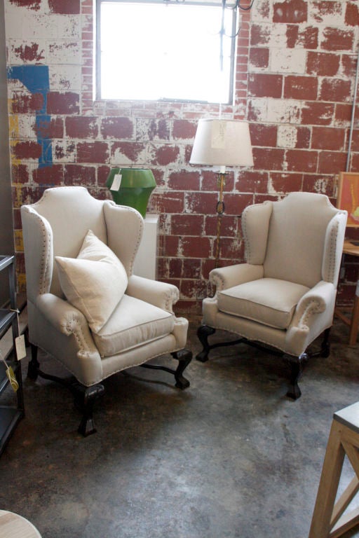18th century Portuguese wingback chair, newly upholstered in natural linen with tack detail.