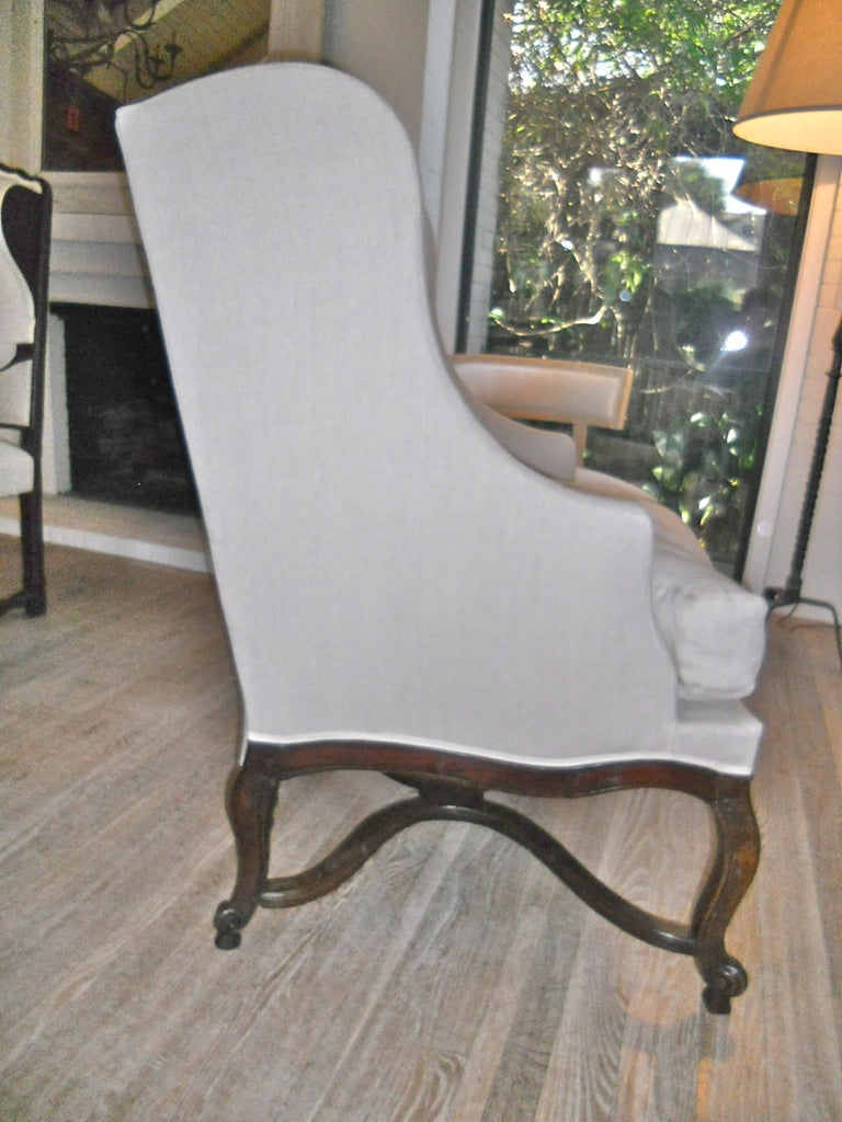 Handsome and large French wingback bergere. Unusually large size. Cabriole legs ending in escargot. Serpentine stretchers. Newly upholstered in Belgium linen.