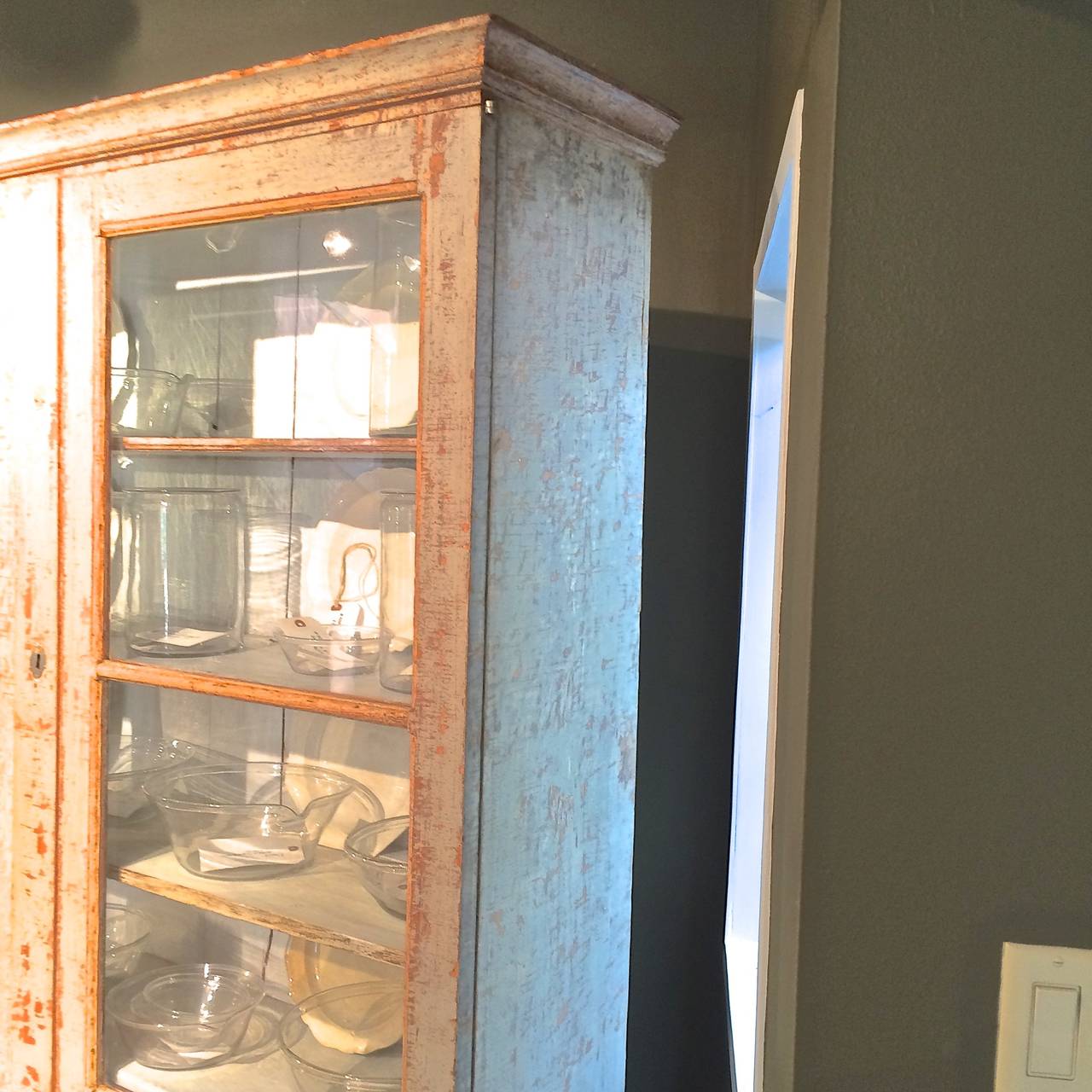 Handsome Swedish dry scraped glazed top cabinet. Upper cabinet with shelves and two hidden drawers. Very narrow. Bottom left has a crack in the glass.