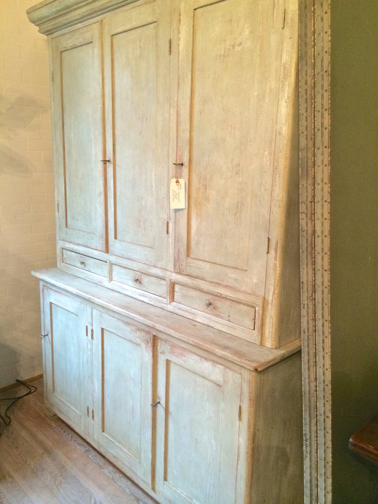Handsome and large Swedish painted cupboard. Three upper doors over thee drawers in upper cabinet on three lower doors with shelves.