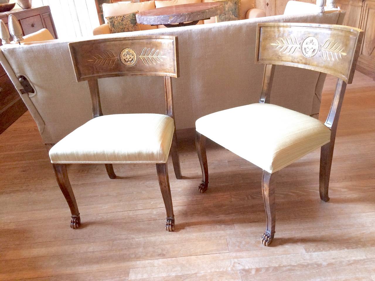 Handsome and decorative pair of Swedish 1920's Klismos chairs by designer Axel Einar Hjort. Made in Birch.Carved bask rail Lion paw feet.