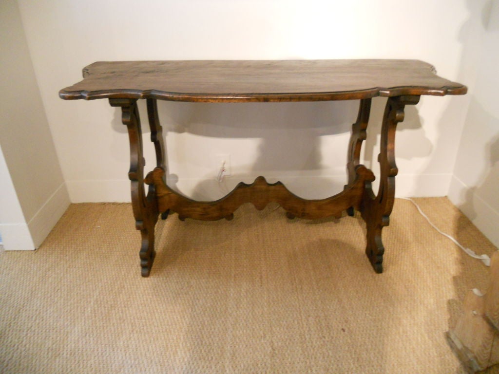 Handsome and large  walnut console.Lyre shaped and pierced legs with serpentine stretcher. Having molded and shaped tops.