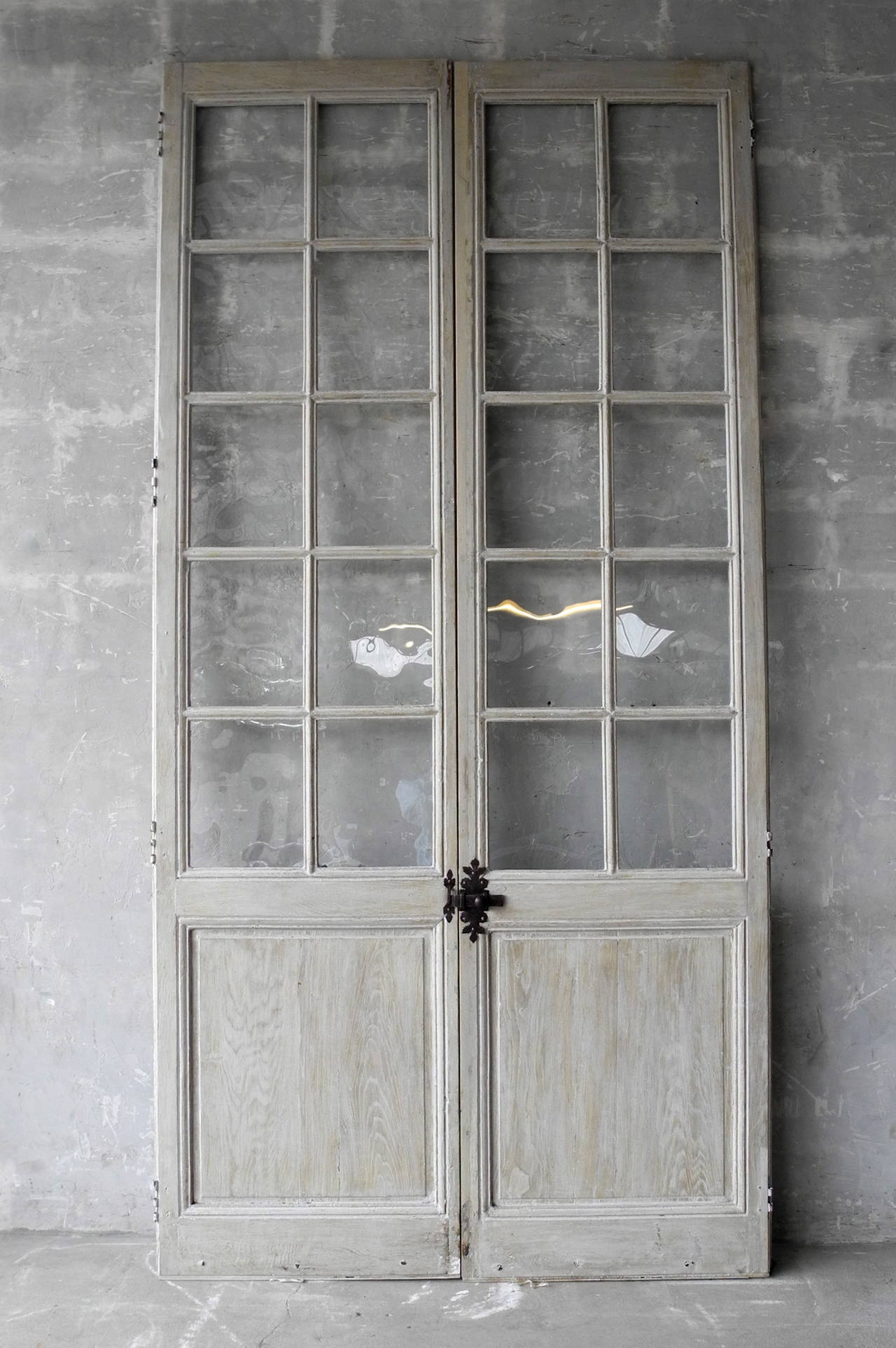 Pair of tall, antique 19th century, provençal French Doors with glass and antique slide bolt. 

At over 9 feet high, these doors boast an impressive stature while the twenty panes of glass retain their sense of elegance. 

The antique slide bolt