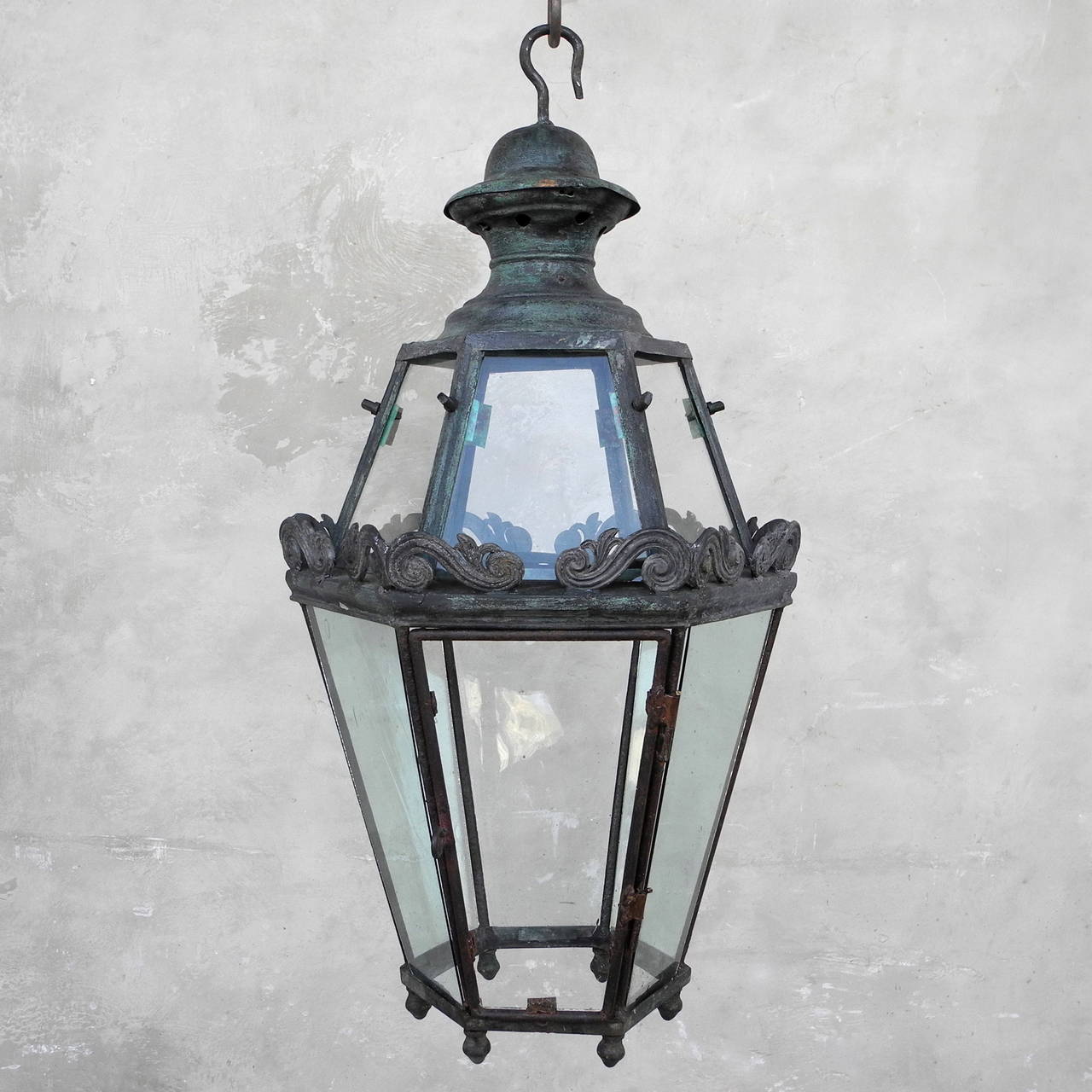 This 18th century French lantern is beautifully preserved. The delicate designs around the middle add an element of uniqueness and femininity to an otherwise plain and masculine lantern. 

The patina of the lantern is a wonderful mix of greens and