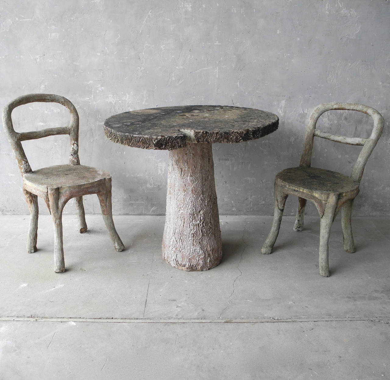 This antique faux bois garden set includes two small chairs and one table. Literally translating to 