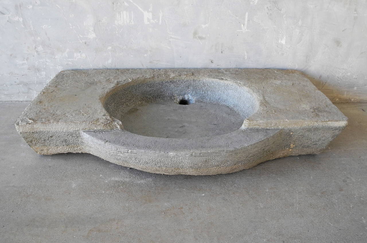 This 18th century stone ever was reclaimed from a domaine outside of Corbières, a village in the Languedoc-Roussillon Region of France. 

Its neutral gray color and stunning patina make this a unique and versatile piece perfect for any powder room