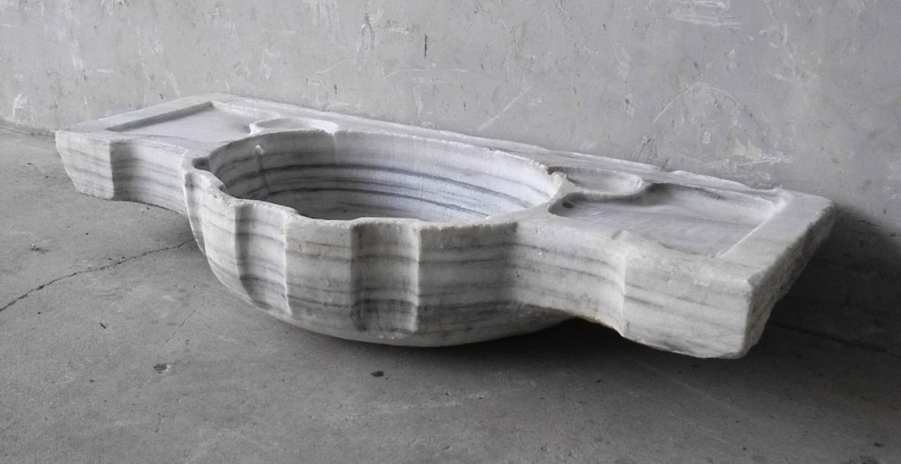 This 19th century white marble evier is stunningly preserved. This sink is carved out of a solid piece of white marble with gray striations running throughout. Perfect for a powder bath, this piece is sure to become the focal point of its new space.