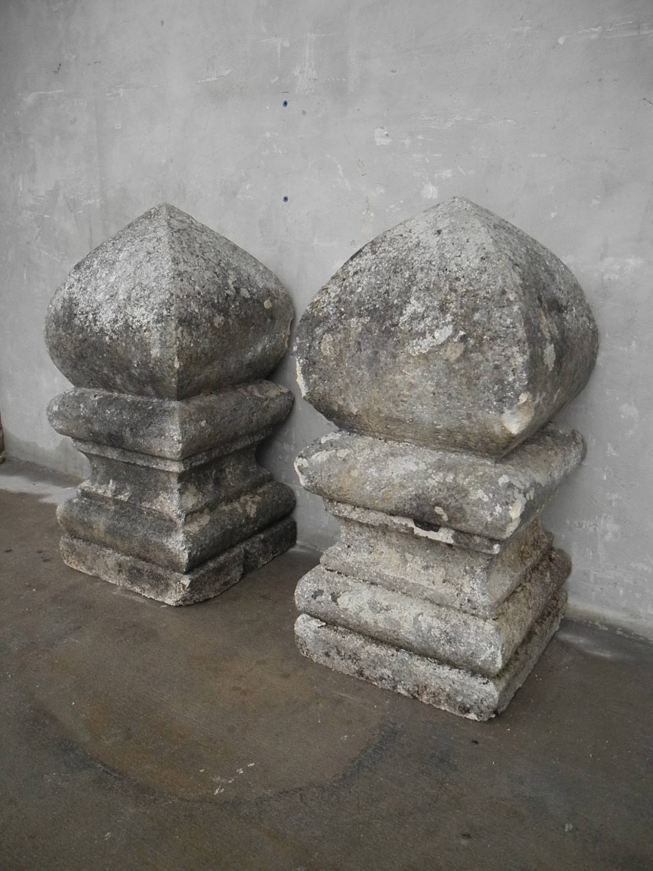 This pair of early 19th century stone finials originally guarded the entrance to a property in Montendre, a commune in the Poitou-Charentes region of France. These substantial pieces are solid, carved stone and sport a beautiful, mottled gray