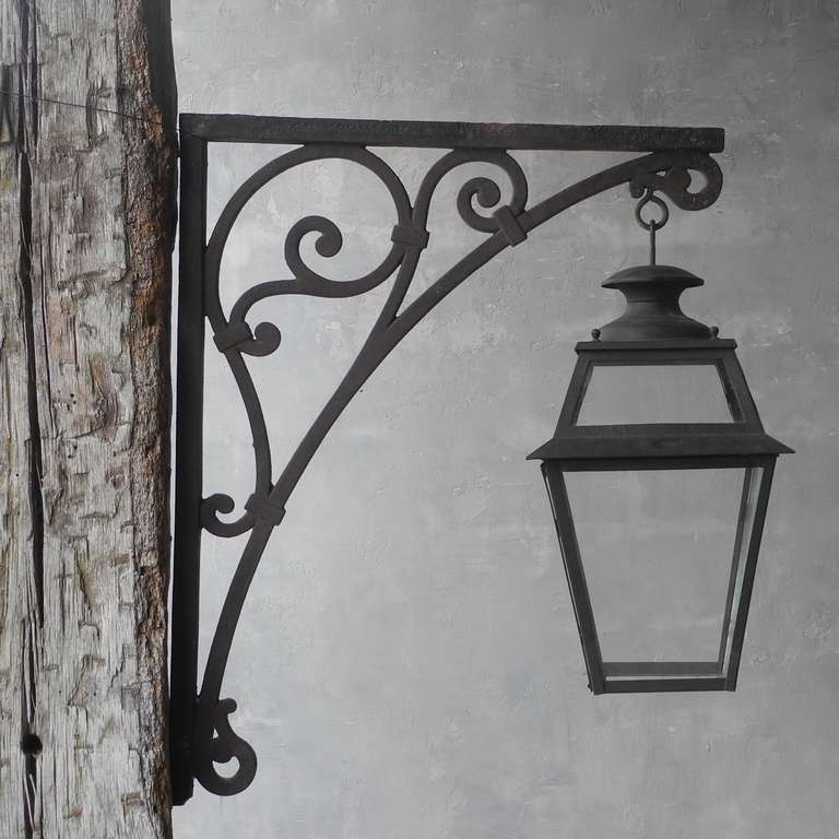 This 19th century antique lantern hangs elegantly from an ornate potence. It is a single piece, so it would stand pride of place on the exterior of your residence. It is relatively large in size, but simple in it's design, making a wonderfully