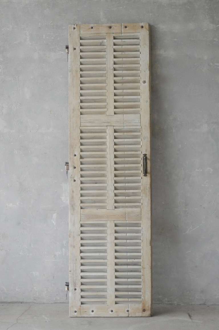 Single 19th century pine shutter that features antique hardware. All slats intact. This shutter would be great for a cabinet door or to cover a small window.