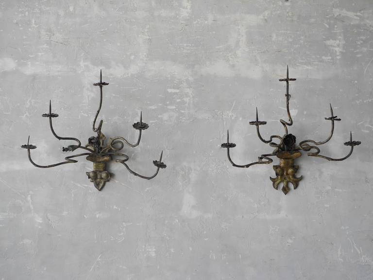 This pair of Louis XIV wall appliques was reclaimed from the Po Valley town of Modena, Italy. Each sconce features 5 winding arms with points for candles on each end. Elegant and refined, these sconces would add an element of intrigue to any indoor