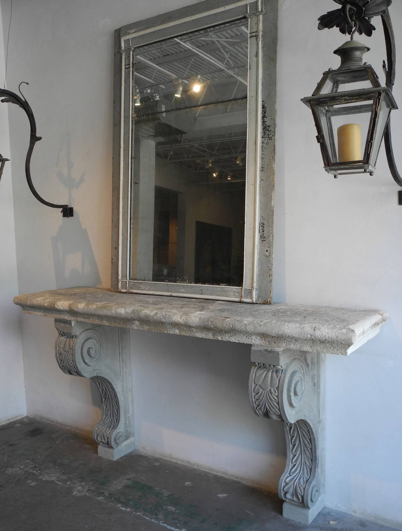 This 18th century console table was reclaimed from the courtyard of a Palazzo in Arezzo, Italy. The grey stone console has unique antique corbel legs. It has detailing in the legs but a simple top and the three pieces combined make for a beautiful