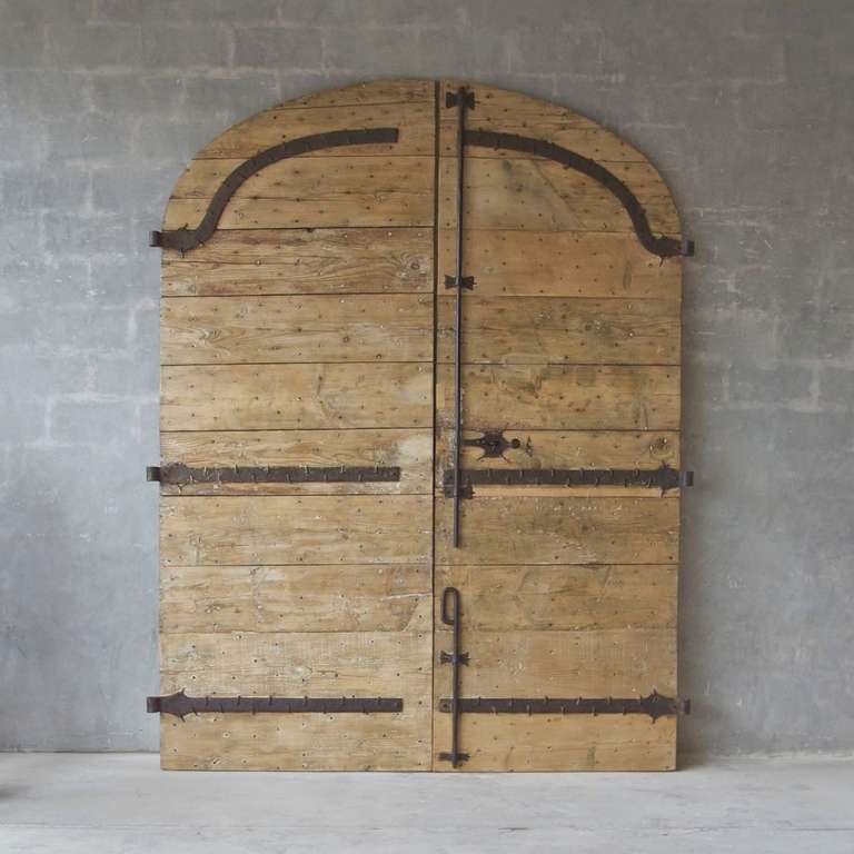 This pair of large 18th century wooden gates were reclaimed from the courtyard entrance to a Maison in Montpellier, France. At 10 feet in height, these gates are monumental in size and stature.