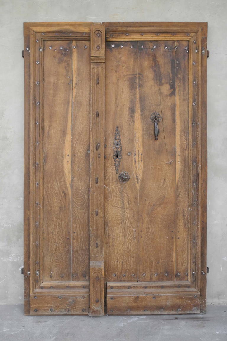 This pair of late 17th century reclaimed entrance doors originally guarded the entrance of a Bastide just north of Toulouse, France. 

These heavy doors with excellently preserved antique hardware would create a stunning entrance to any home. They