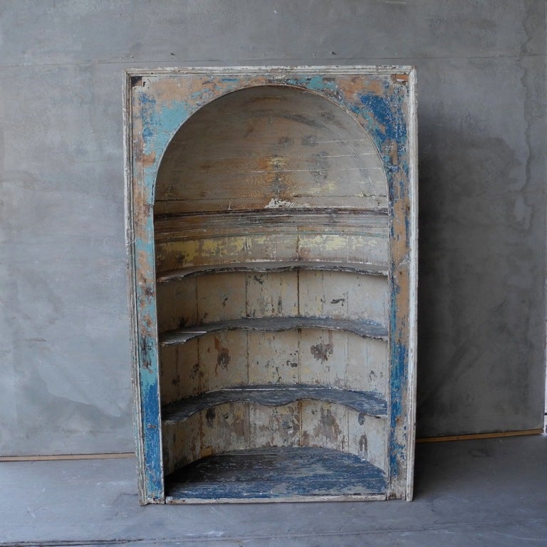 This early 18th century painted wooden niche was reclaimed from a village house outside of London. It is rounded making it easy to build into a space. It can also stand alone. It has a wonderful patina of whites, blues, and browns. It is a great