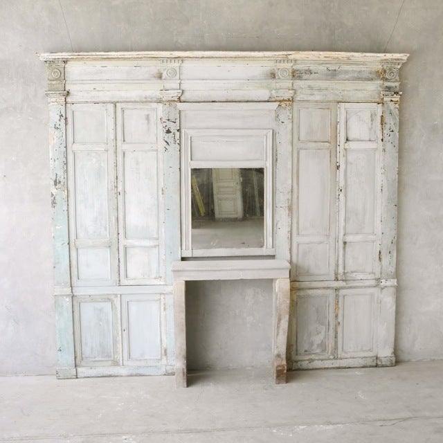 This early 19th century "boiseries" wall has been reclaimed onsite. It has a beautiful bleached finish with some patina and aged marks. It is from Vieux Lille, France. It also includes a white stone 19th century mantel that can be