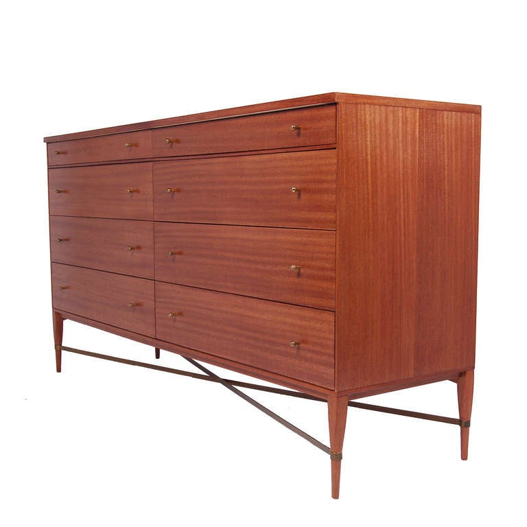 Model 1006 chest with two narrow and six wide drawers; mahogany case and legs with brass drawer pulls and support stretchers. Made by Calvin Group.