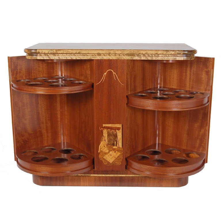 Mahogany case with inlaid figures and designs in birch, burl walnut and rosewood.  Two doors open to reveal section for glasses, top opens up to reveal aluminum tray. Signed by artist and dated, Birger Ekman 1939.