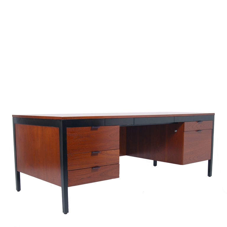 Walnut desk with black metal frame; freestanding.Three small drawers along front with one file drawer and three regular drawers. Retains label.
Made by Herman Miller.
