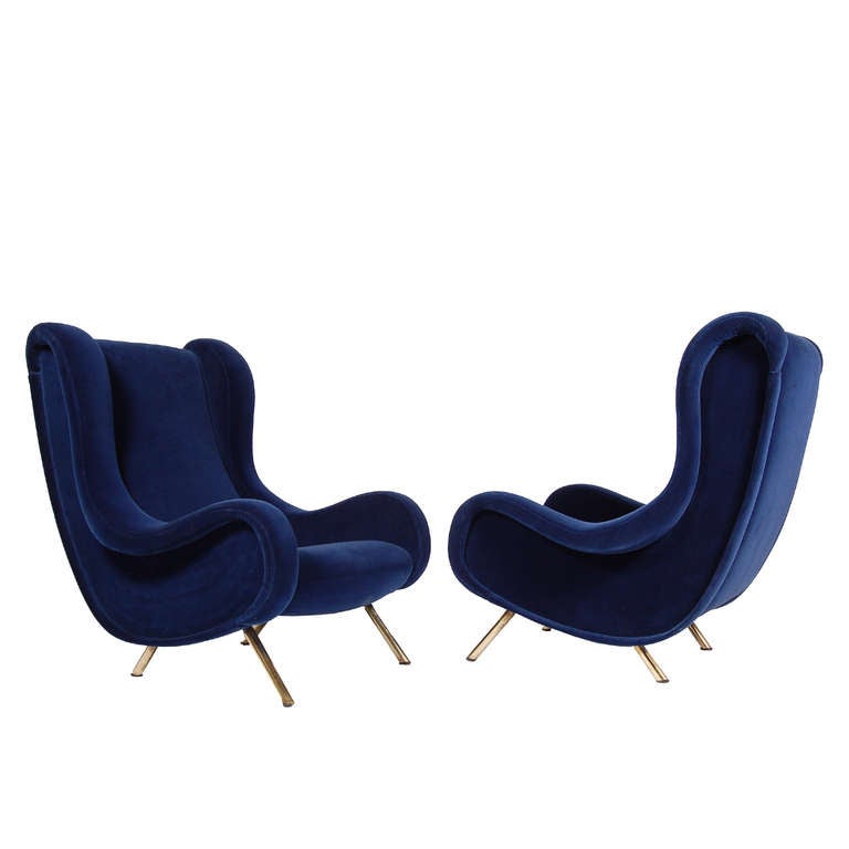 Low fully upholstered wing chairs, low version, on brass legs.
Made by Arflex.