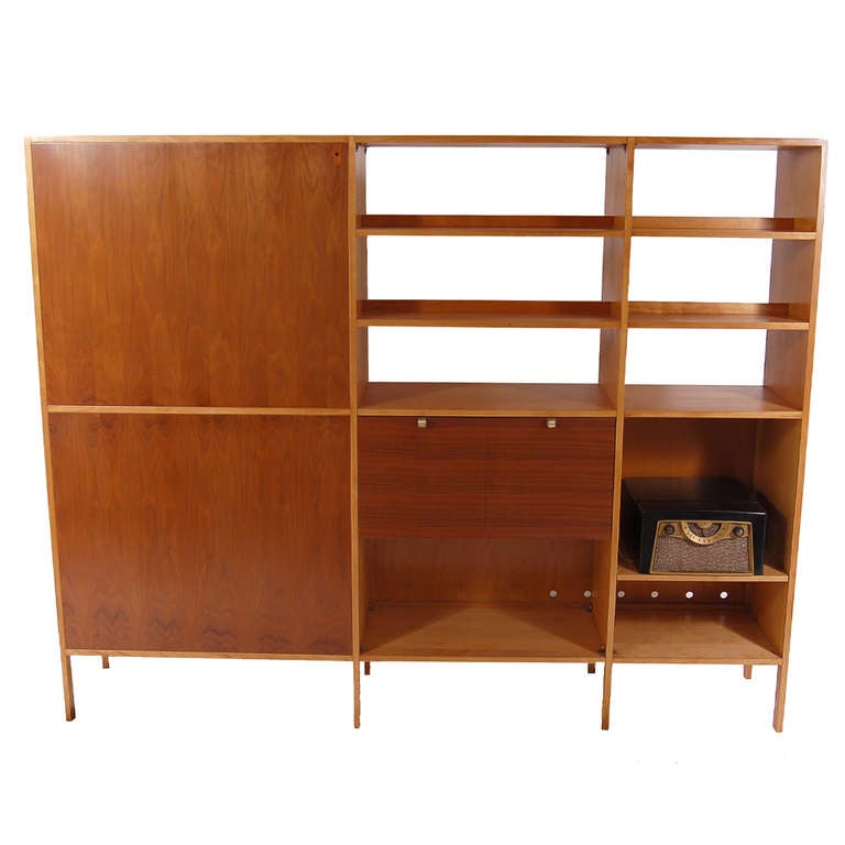 Scarce free-standing room divider, walnut and birch having doors with adjustable shelves and drawers on one side, the other with drop down doors, also with adjustable shelves. Open sections for display.
Retains label in drawer. Made by Herman