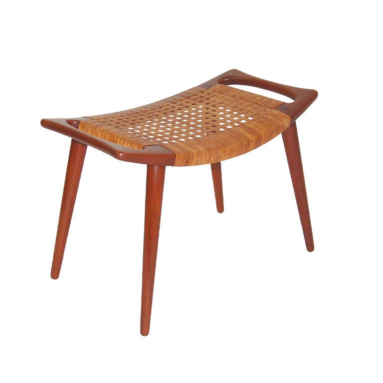 Elegant occasional stool with flat cane top and solid teak frame and legs. Made by Johannes Hansen.
