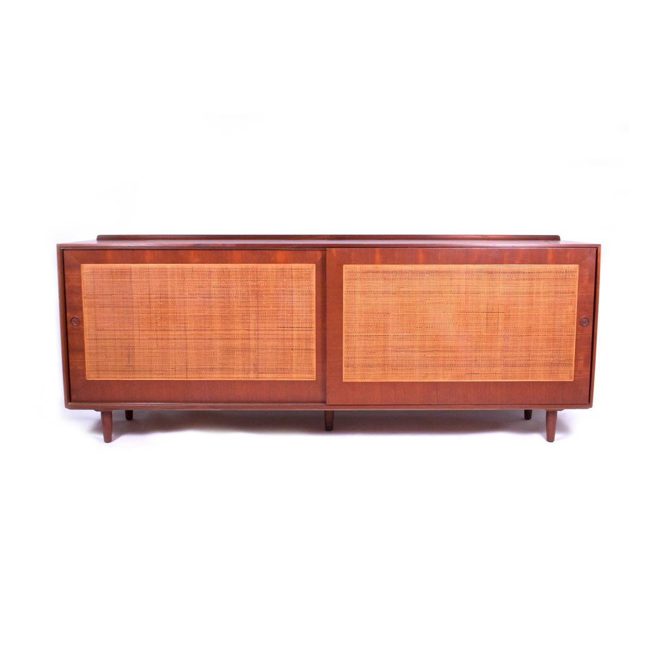 Teak cane doors freestanding sideboard, two sliding doors, three drawers and shelving on a five cone legs, this model not made in Denmark only US.