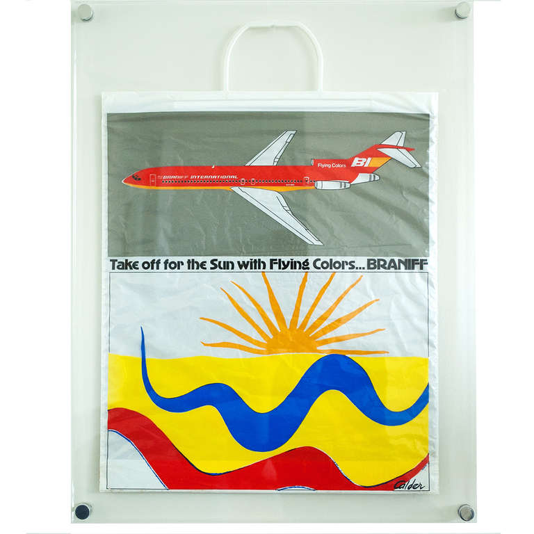 Double sided plastic bag, one side in Spanish, with images of Calder's famous painted Braniff airplane.  Made in 1973.  Mounted in plastic frame. Several others available, unframed.